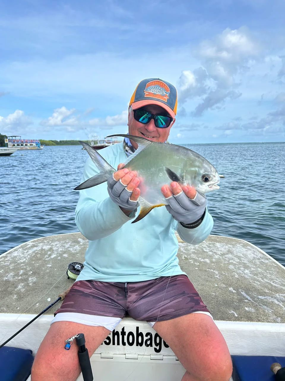 A permit held in both hands over the gunwale