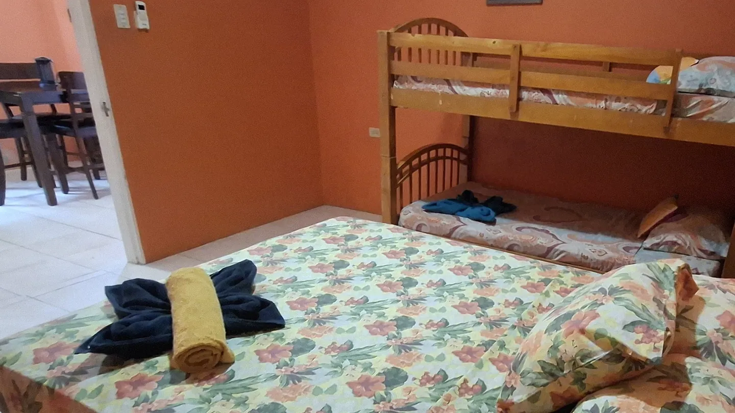 The orange bedroom from its doorway, looking through to the dining area